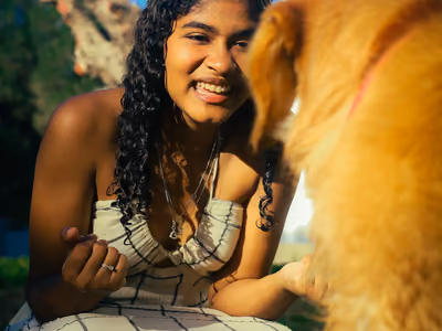 Tutora abraçando seu cachorro ao sol